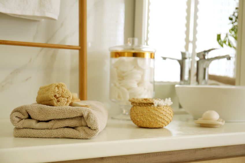 toiletries on white countertop in bathroom with mirror